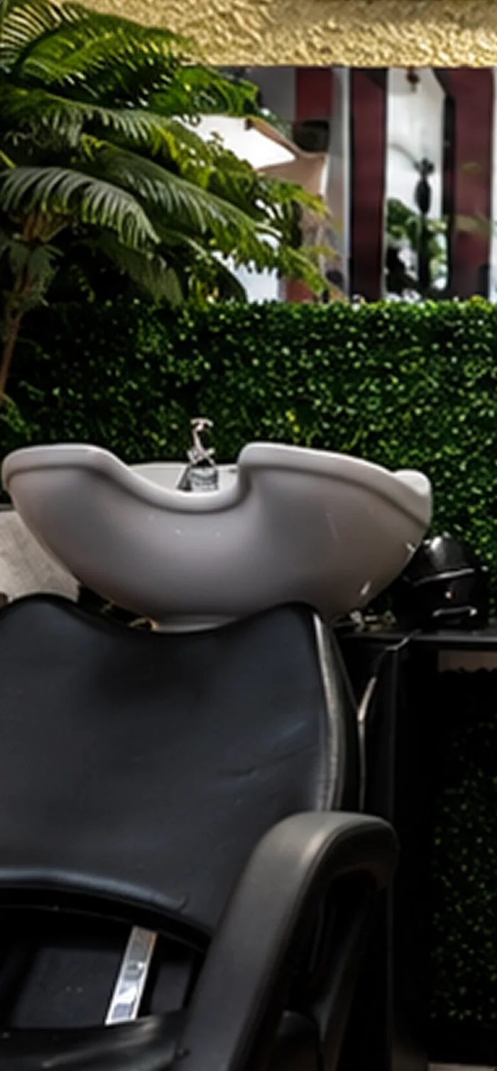 Shampoo bowl in front of a plant wall