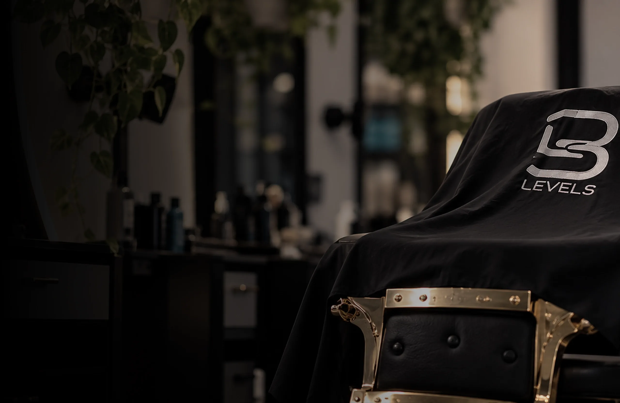 Gold barber chair draped in a black cape at the Jireh shop